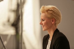 Blonde woman in a black jacket with a slicked-back bob